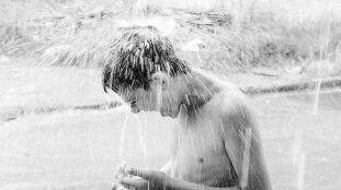 Ein Junge bekommt eine kalte Wasserdusche